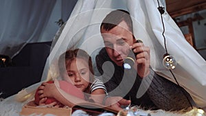 happy family at home dream. dad and daughter happy family at home reading a book in stay home the evening in homemade