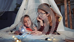 Happy family at home dream. Mom and daughter stay home happy family at home reading a book in the evening in homemade