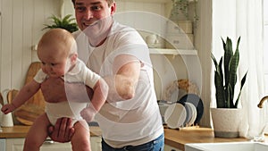 Happy family at home. Father lifting in air little toddler child. Dad baby girl playing having fun together at home