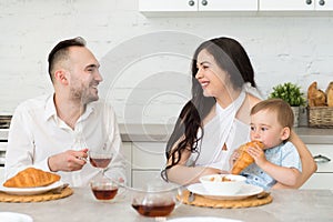 Happy family in home kitchen married couple with small child