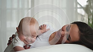 Happy family at home. Mother with little toddler child daughter. Mom and newborn baby girl relax playing having fun