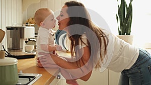 Happy family at home. Mother playing with little toddler child in kitchen. Mom baby relax playing having fun together