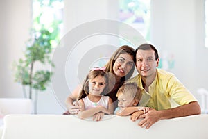 Happy family at home. Parents and kids on couch