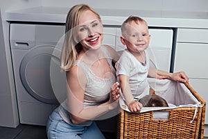Happy family home weekend morning bathroom washing machine.mother and little son in laundry room Washer washed clothes