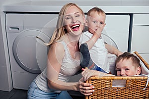 Happy family home weekend morning bathroom washing machine.mother and little son in laundry room Washer washed clothes