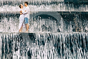 Happy family honeymoon holiday. Couple in cascade waterfall pool.