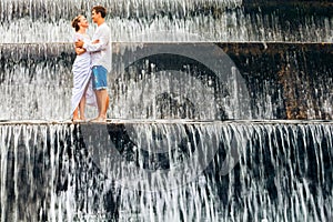 Happy family honeymoon holiday. Couple in cascade waterfall pool.