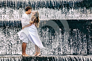 Happy family honeymoon holiday. Couple in cascade waterfall pool.