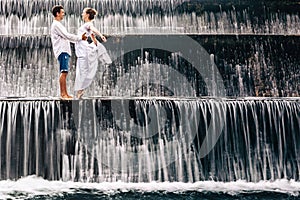 Happy family honeymoon holiday. Couple in cascade waterfall pool.