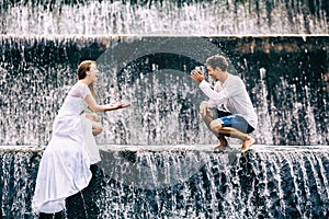 Happy family honeymoon holiday. Couple in cascade waterfall pool.