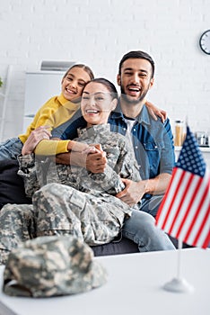 Happy family hugging mom in military
