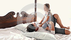 Happy Family Idyll Little Child Daughter Jump On Father Arms And They Fall On A Bed