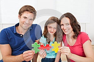 Happy family joining puzzle pieces