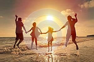 Happy family jumping on the beach