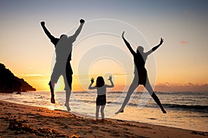 Happy family jumping at the beach