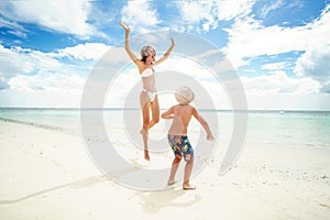 Happy family jumping on the beach. Mom and son having fun on summer vacation. Travelers