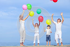 Happy family jumping on the beach at the sunset time.