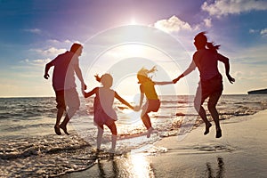 Happy family jumping on the beach