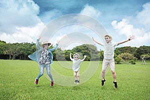 Happy  family jumping on the grass and enjoy summer vacation