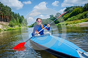 Happy family kayaking on the river on a sunny day during summer vacation