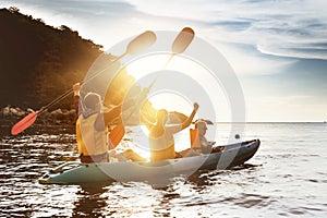 Happy family kayaking sunset sea