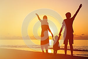 Happy family with kid having fun on sunset beach