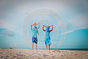 Happy family with kids play walk on beach