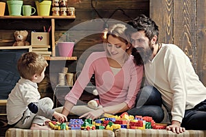 Happy family. Kids playing with toys. Father, mother and cute son play with constructor bricks. Caring parents concept.