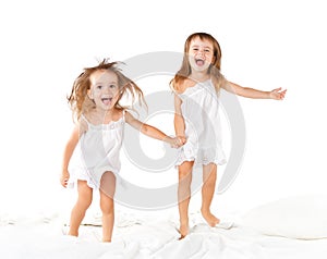 Happy family . kids twin sisters jumping on the bed, playing an
