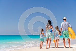 Happy family with kids walk on the beach at sunset