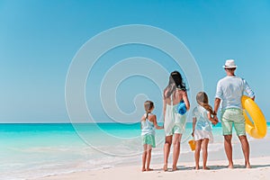 Happy family with kids walk on the beach at sunset