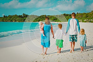 Happy family with kids walk on tropical beach