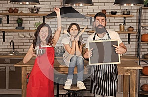 happy family in kitchen. copy space on board. family in kitchen making breakfast together. small girl have fun with mom