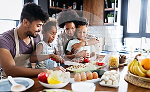 Happy family in the kitchen having fun and cooking together. Healthy food at home.