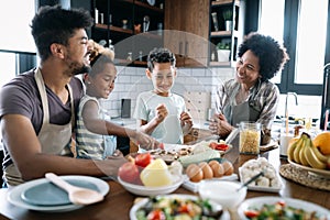 Happy family in the kitchen having fun and cooking together. Healthy food at home.