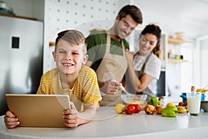 Happy family in the kitchen having fun and cooking together. Healthy food at home.