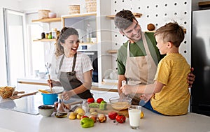 Happy family in the kitchen having fun and cooking together. Healthy food at home.