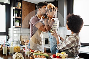 Happy family in the kitchen having fun and cooking together. Healthy food at home.