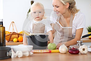 Happy family in the kitchen. Mother and child daughter cooking pasta