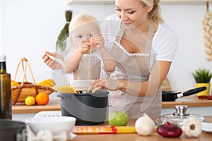 Happy family in the kitchen. Mother and child daughter cooking pasta