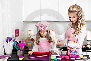 Happy family in the kitchen. mother and child daughter preparing the dough