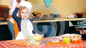 Happy family in kitchen. mother and child daughter preparing dough, bake cookies