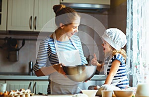 Happy family in kitchen. mother and child preparing dough, bake