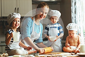 Happy family in kitchen. mother and children preparing dough, ba