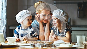 Happy family in kitchen. mother and children preparing dough, ba