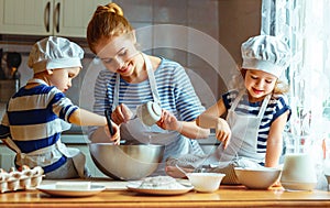 Happy family in kitchen. mother and children preparing dough, ba