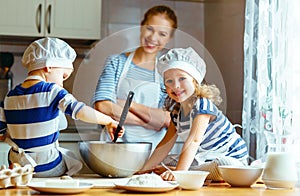 Happy family in kitchen. mother and children preparing dough, ba