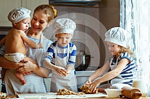 Happy family in kitchen. mother and children preparing dough, ba