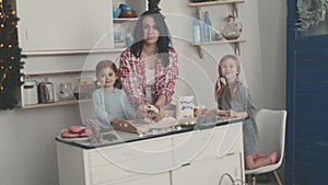 Happy family in the kitchen. Mother and children preparing the dough, bake cookies