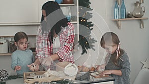 Happy family in the kitchen. Mother and children preparing the dough, bake cookies